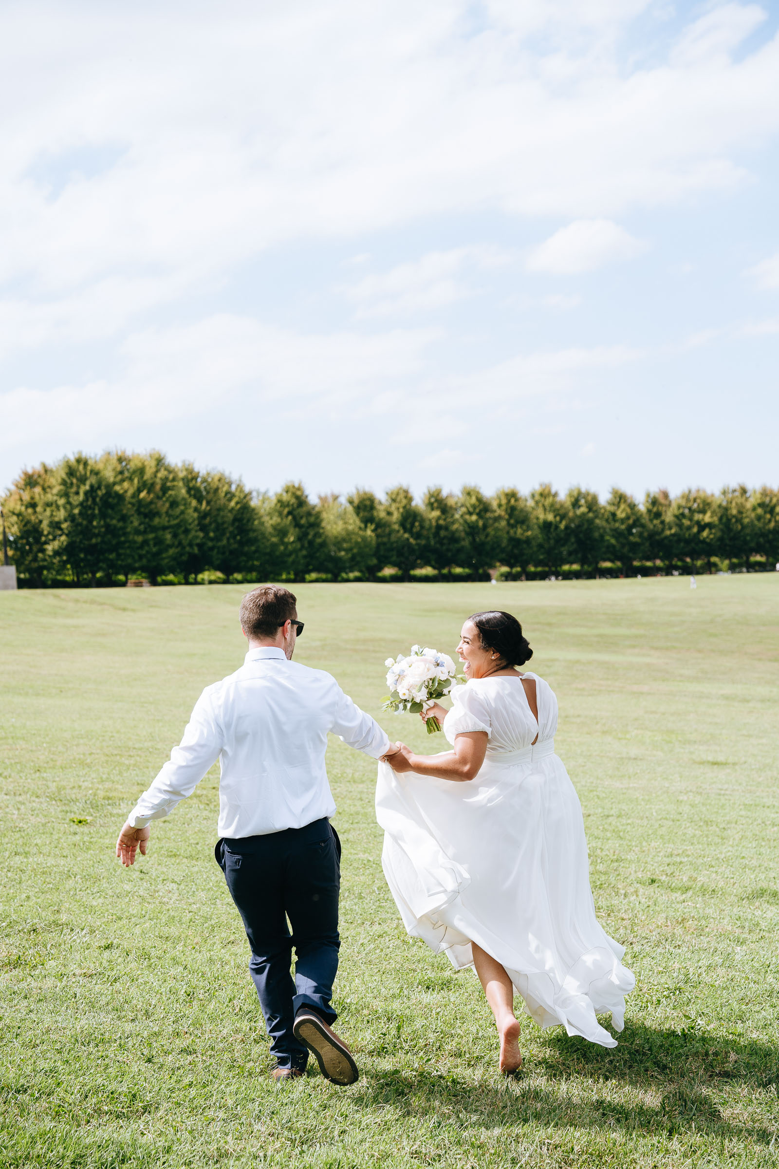 bride and groom running while holding hands