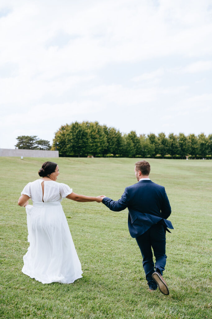 bride and groom running while holding hands