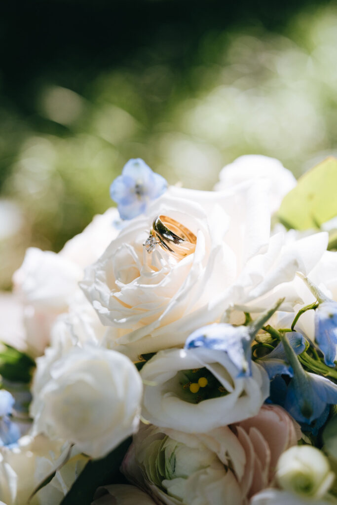 A pair of wedding rings resting in a wedding bouquet