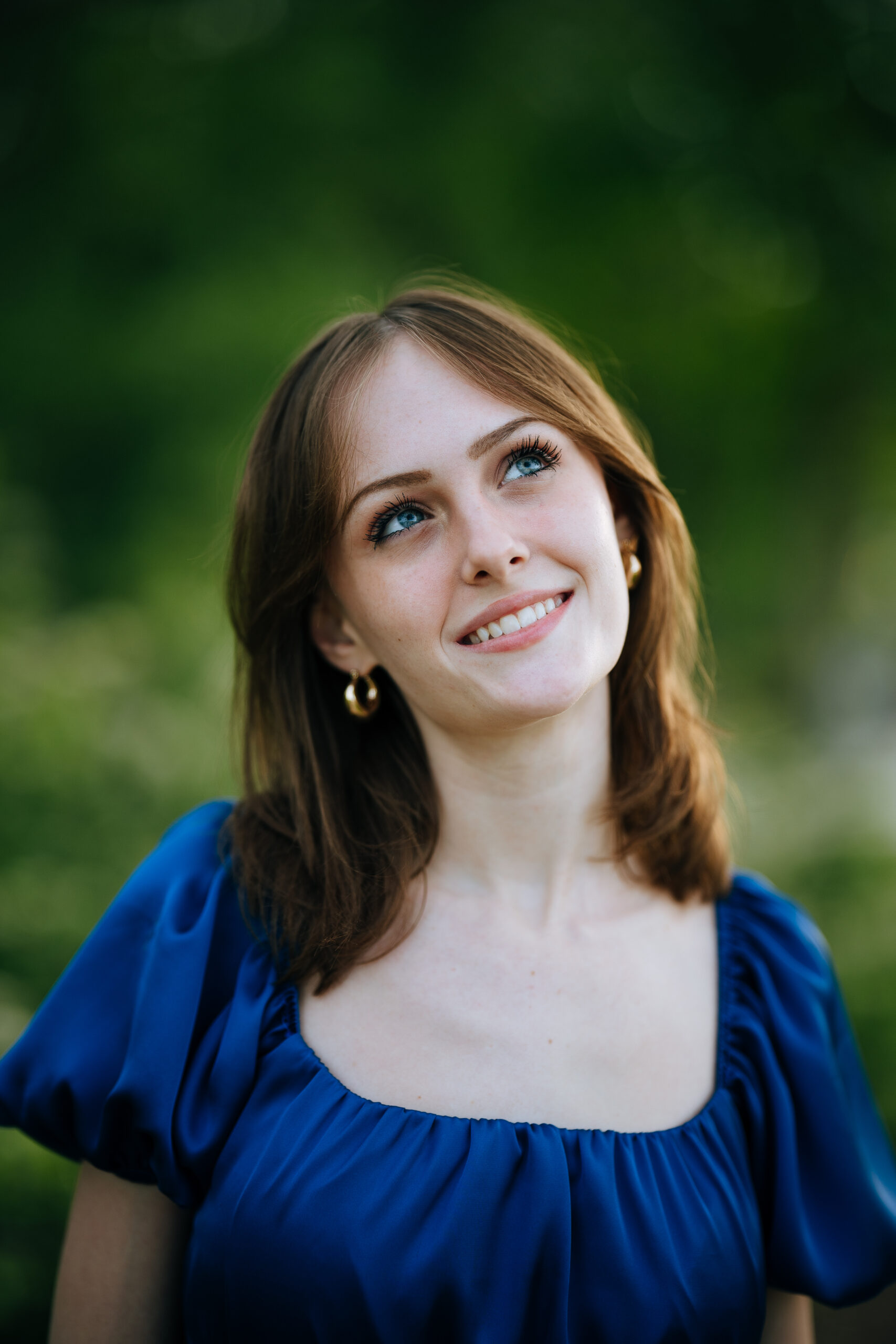 Headshot of girl looking up to the side wearing a blue dress