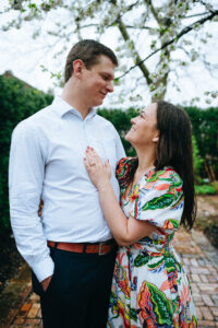 Couple looking at each other while posing to show off engagement ring