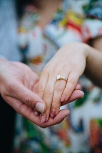 Man holding fiancee's hand to show off her engagement ring
