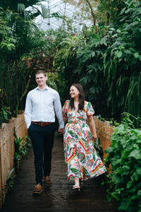 couple holding hands while walking and smiling